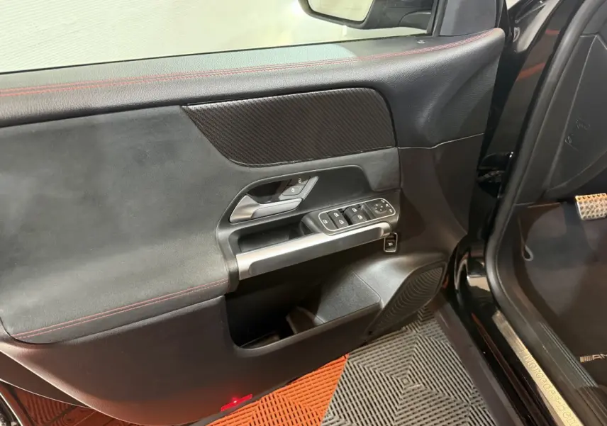 Intérieur côté conducteur de la porte noire du Mercedes GLB 200 d AMG Line 2020 avec commandes et insert carbone.