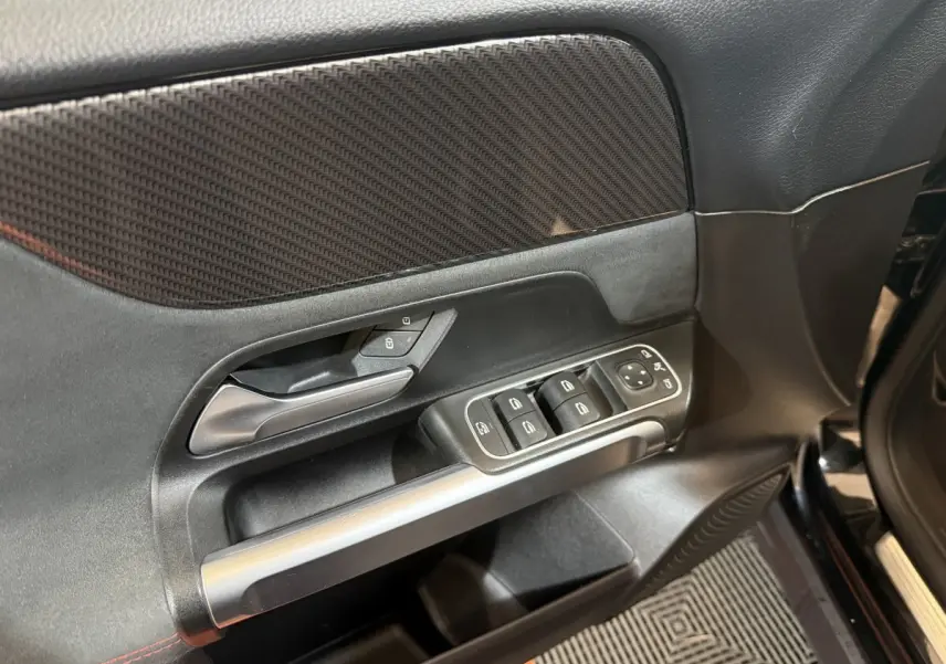 Détail de la porte avant gauche noire du Mercedes GLB 200 d AMG Line 2020 avec commandes des vitres et verrouillage.