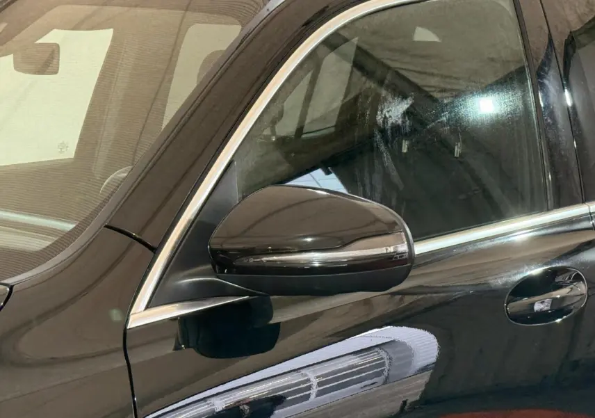 Gros plan sur le rétroviseur côté conducteur noir brillant du Mercedes GLB 200 d AMG Line 2020.