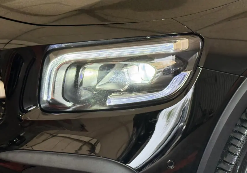 Gros plan sur le phare avant droit LED du Mercedes GLB 200 d AMG Line noir, soulignant ses lignes modernes et précises.