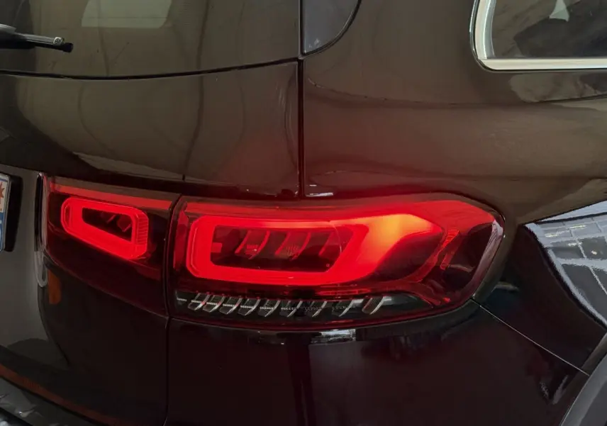 Gros plan sur le feu arrière droit rouge d’un Mercedes GLB 200 d AMG Line noir 2020, finition brillante.