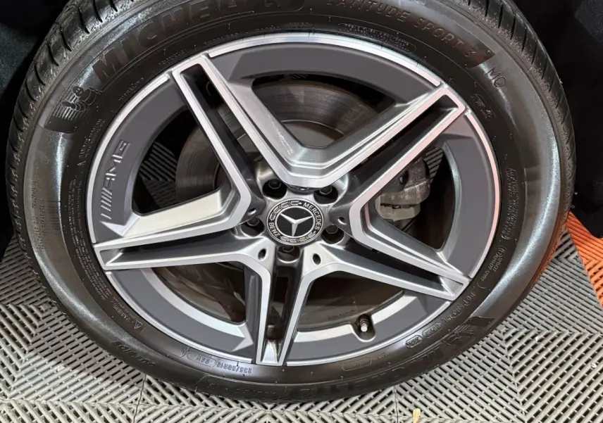 Gros plan sur la jante AMG gris mat et pneu Michelin d’un Mercedes GLB 200 d noir, détail de la roue avant.
