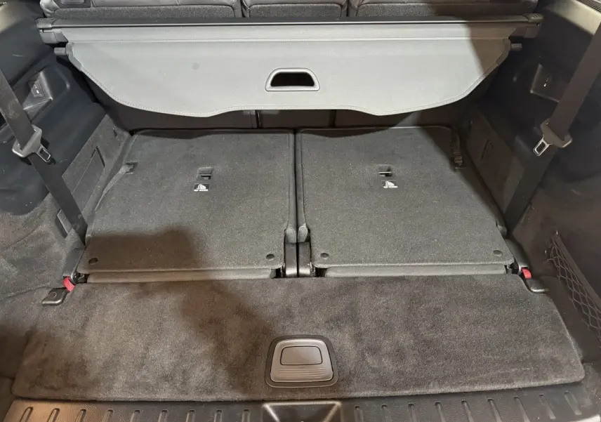 Vue plongeante sur le coffre noir du Mercedes GLB 200 d AMG Line avec la troisième rangée de sièges rabattue.