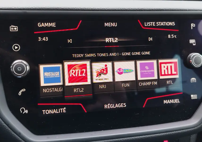Écran tactile central de la SEAT Arona 2020 affichant les stations radio avec interface noire et détails rouges.