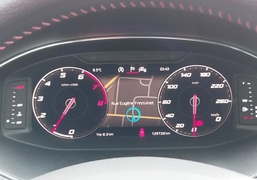 Vue rapprochée du tableau de bord numérique de la SEAT Arona 2020, affichant la navigation et compteurs en blanc et rose.