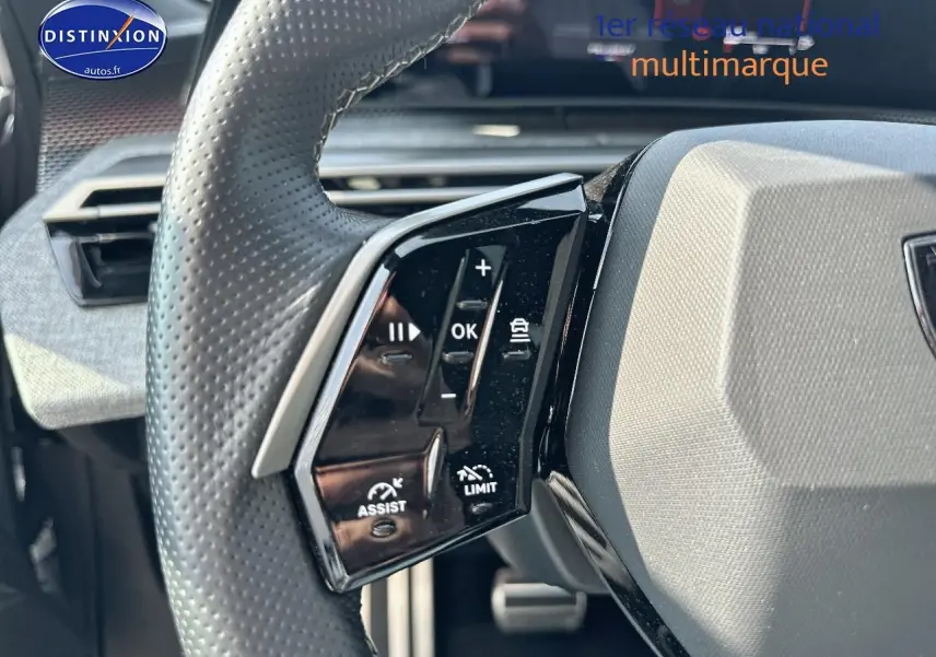 Gros plan sur le volant cuir perforé de la Peugeot 3008 gris Artense, avec commandes multifonctions visibles à gauche.