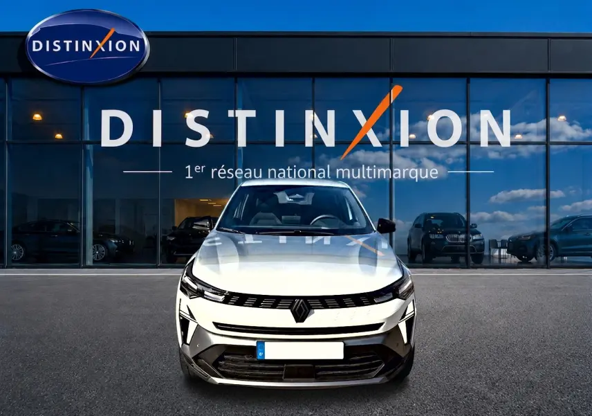 Vue frontale d'un Renault Symbioz blanc nacré garé devant une vitrine avec logo Distinxion.