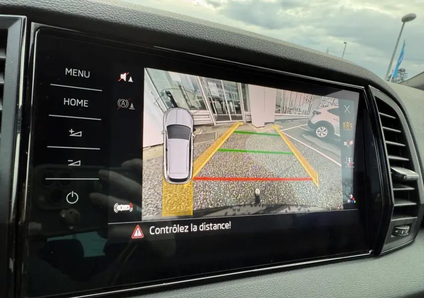 Écran multimédia du Skoda Karoq noir Magic nacré montrant la caméra de recul avec guidage de trajectoire coloré.