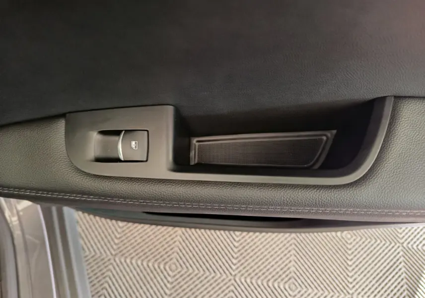 Poignée intérieure côté gauche avec bouton de lève-vitre sur porte gris foncé d'Alfa Romeo Stelvio 2024 Sprint