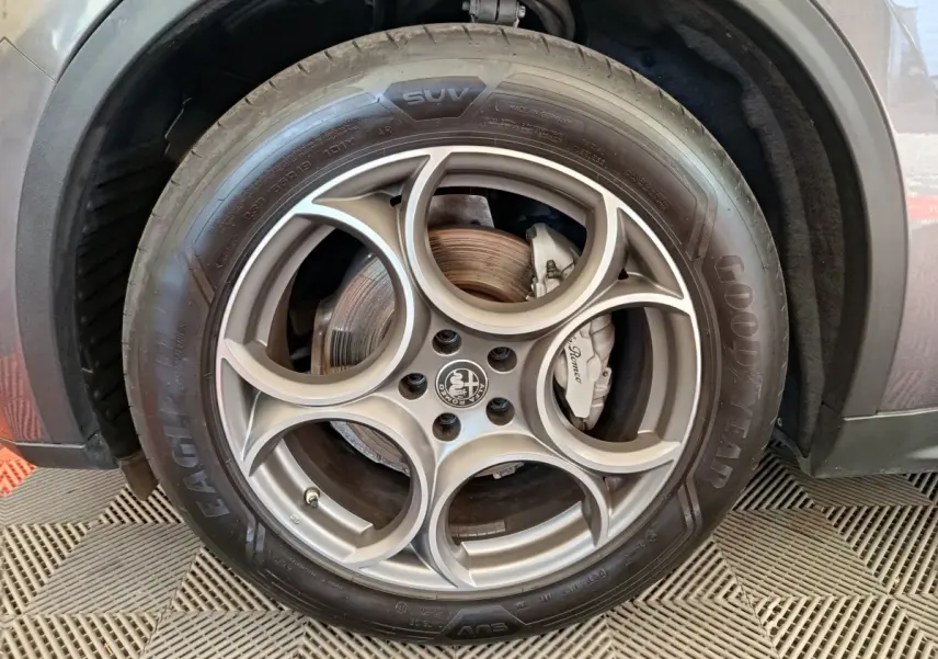 Gros plan sur la roue avant droite gris foncé d'un Alfa Romeo Stelvio 2.2 TD 160 AT8 Sprint avec jante en alliage distinctive.