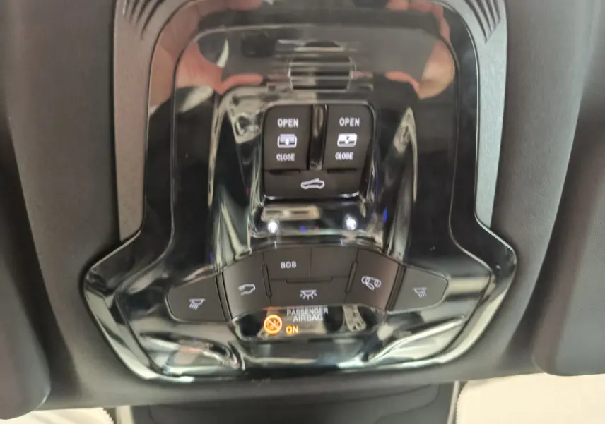 Vue rapprochée du panneau de commandes de toit ouvrant et éclairage intérieur noir brillant dans un Alfa Romeo Stelvio gris foncé 2024.