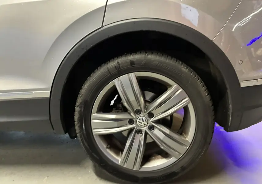 Gros plan sur la roue arrière droite gris métallisé d’un Volkswagen Tiguan 2.0 TDI 150 Carat de 2017 avec jante alliage 19 pouces.