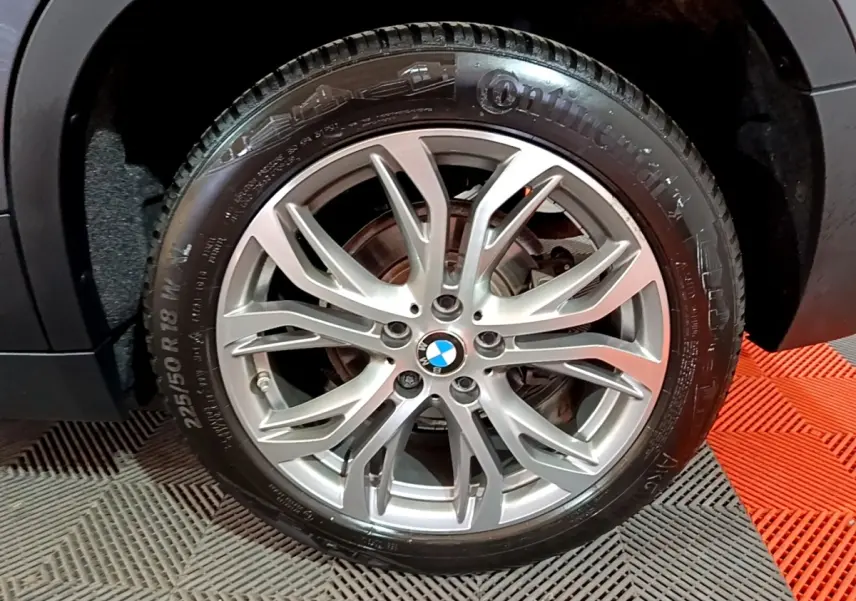 Gros plan sur la roue avant droite du BMW X2 gris foncé, mettant en valeur la jante alliage à multiples branches.