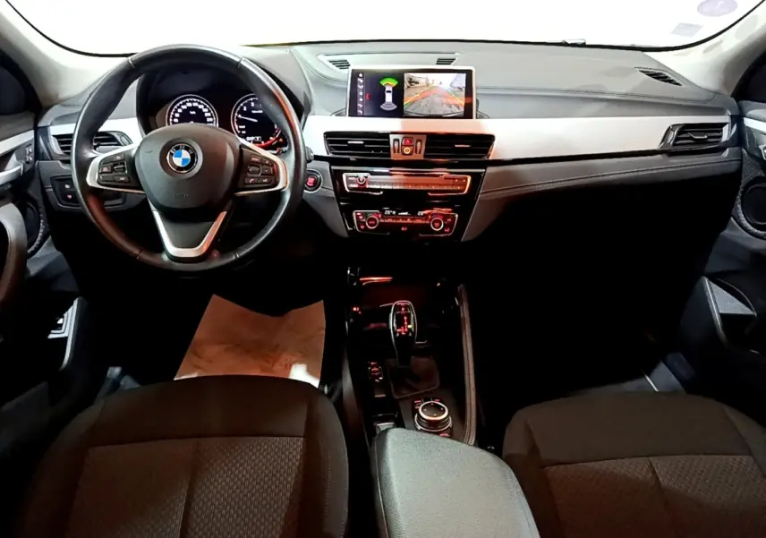 Intérieur BMW X2 sDrive18i 2021 vue avant, tableau de bord noir avec écran central et volant cuir multifonctions.