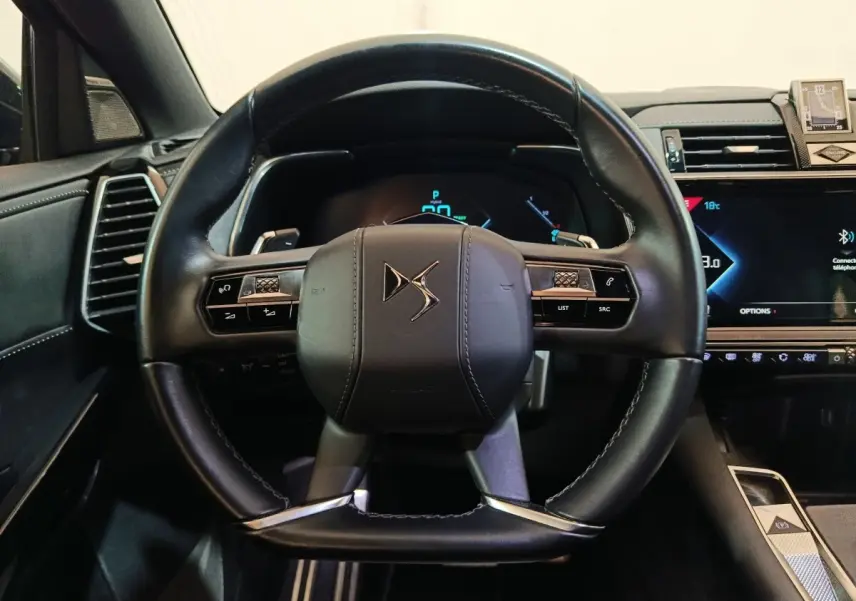 Vue rapprochée du volant cuir noir DS7 Crossback E-TENSE 4x4 2022 avec tableau de bord digital et commandes intégrées.