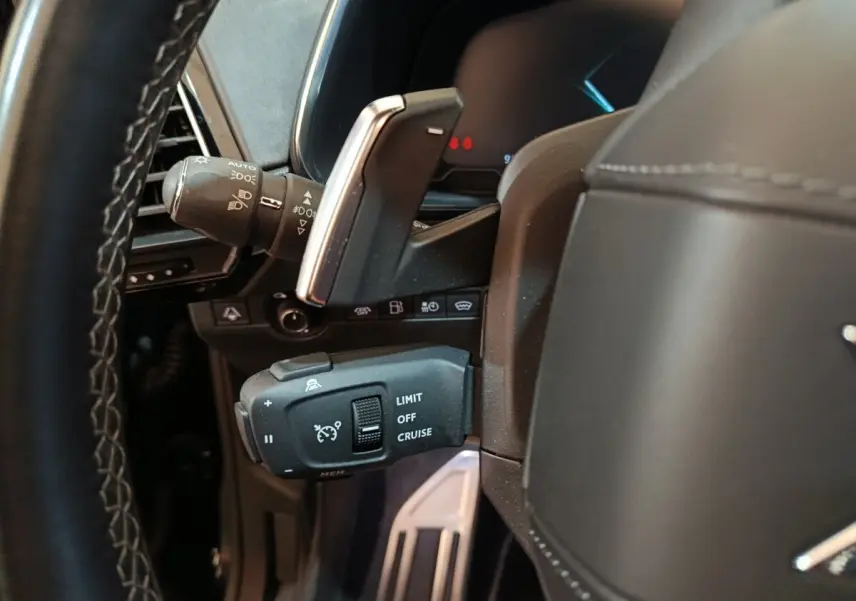 Gros plan sur la commande de régulateur de vitesse au volant cuir noir du DS7 Crossback E-TENSE 2022.