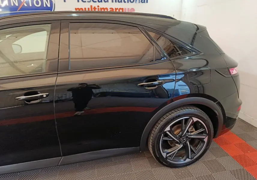 Vue latérale droite du DS7 Crossback noir, mettant en valeur la porte arrière et la roue arrière au design moderne.