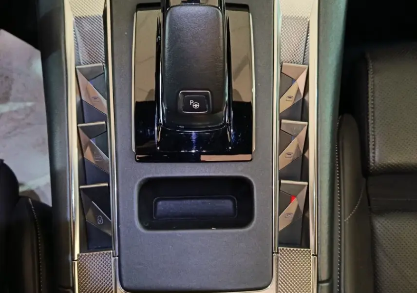 Vue plongeante sur la console centrale noire du DS7 Crossback E-TENSE 4x4 300 avec levier de vitesses et boutons triangulaires.