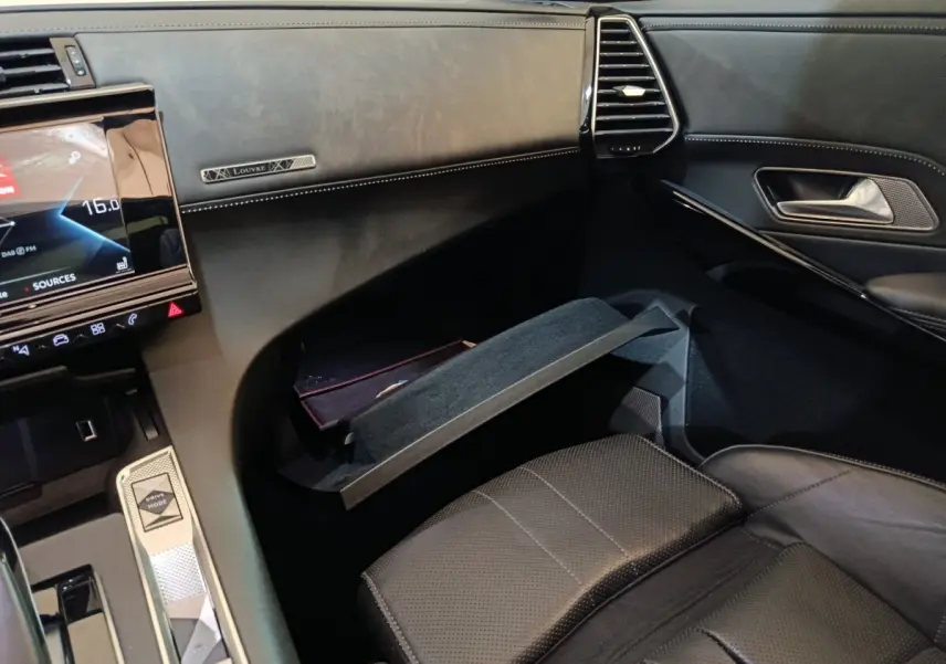 Intérieur noir du DS7 Crossback E-TENSE 4x4 300 Louvre, vue côté passager avec boîte à gants ouverte et tableau de bord.