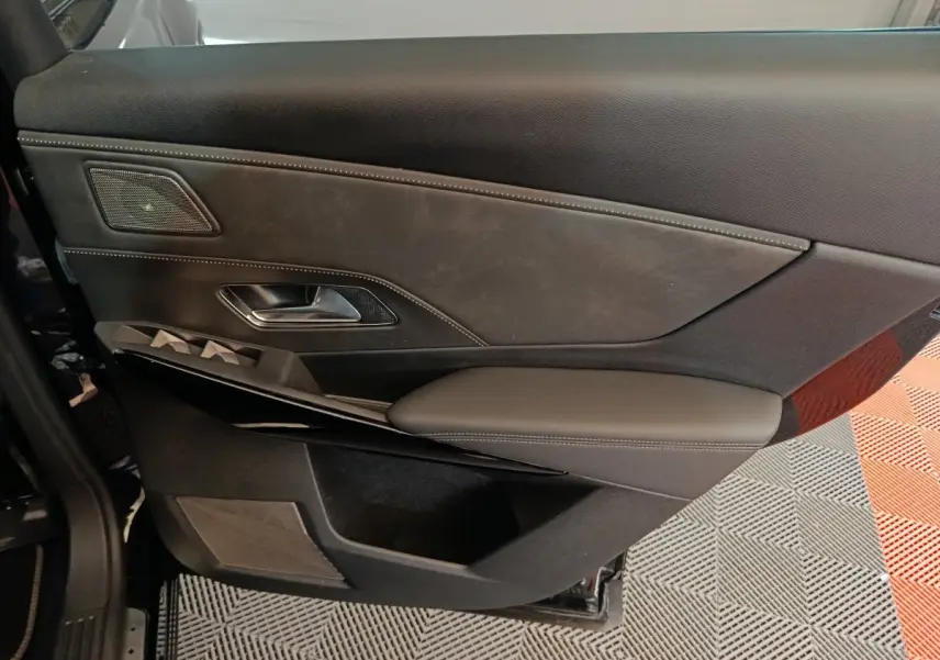 Gros plan sur la porte intérieure côté gauche du DS7 Crossback E-TENSE 4x4 300 noir, avec garniture cuir et commandes intégrées.