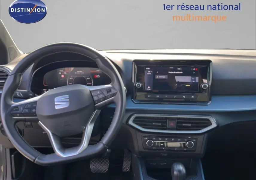Vue intérieure avant du tableau de bord du SEAT Arona gris magnétique, avec volant multifonction et écran tactile central.
