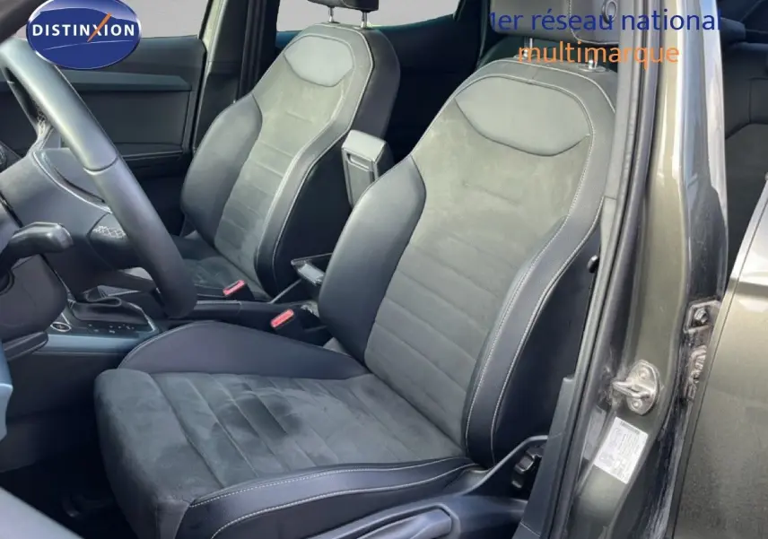 Vue intérieure côté conducteur du SEAT Arona gris magnétique, sièges en cuir et alcantara avec surpiqûres blanches.