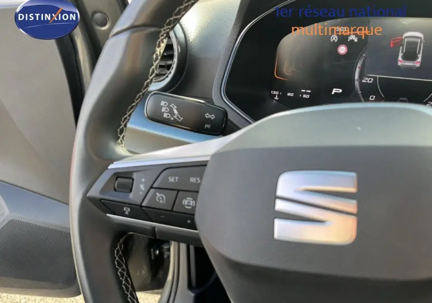 Gros plan sur le volant cuir noir de la SEAT Arona 2025 avec commandes intégrées et tableau de bord numérique.