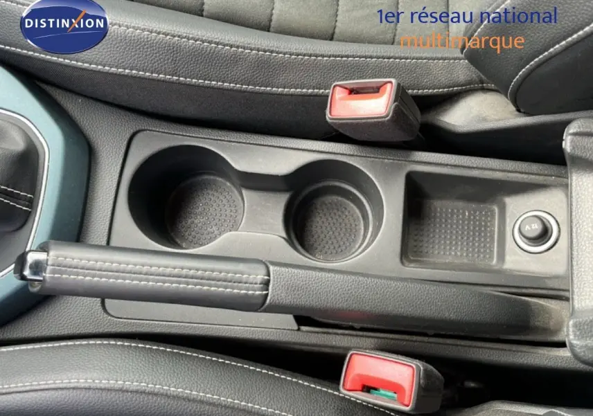 Vue rapprochée de la console centrale avec frein à main et porte-gobelets du SEAT Arona gris métallique 2025.