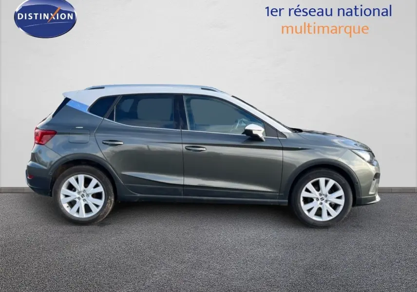 Vue de profil côté gauche d'un SEAT Arona gris magnétique avec toit blanc, sur fond neutre extérieur.