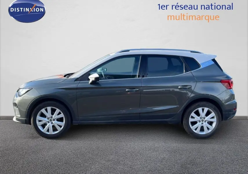 Vue de profil côté gauche d’un SEAT Arona gris magnétique avec toit blanc, roues alliage 17 pouces, finition X-PERIENCE SPECIAL.