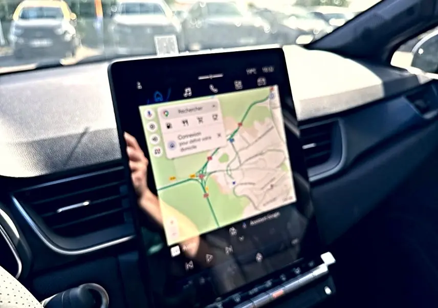 Vue intérieure centrée sur l'écran tactile du tableau de bord du Renault Symbioz gris rafale avec navigation affichée.