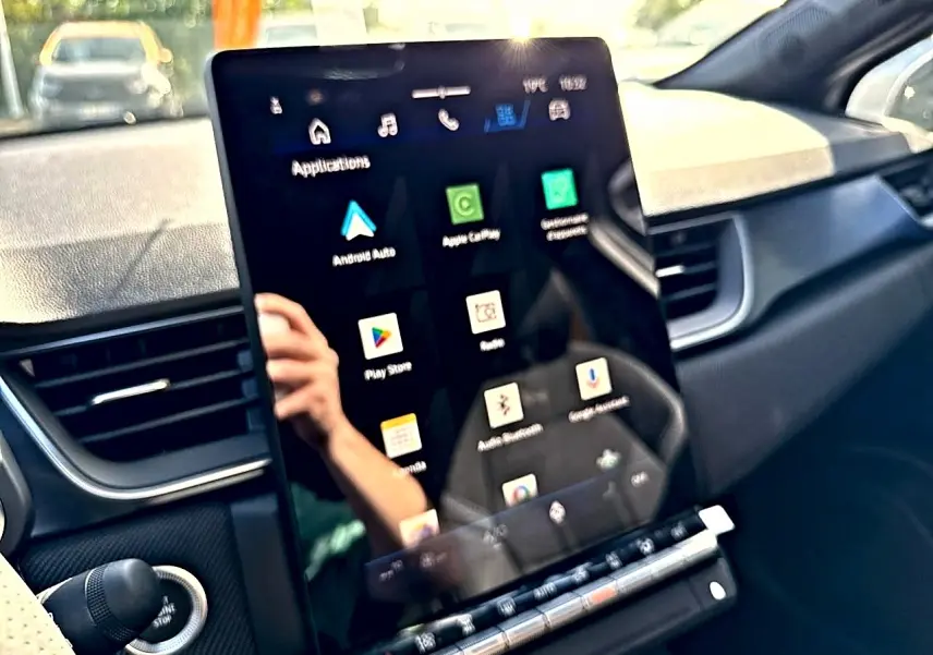 Vue intérieure du tableau de bord de la Renault Symbioz gris rafale, avec écran tactile central affichant applications connectées.