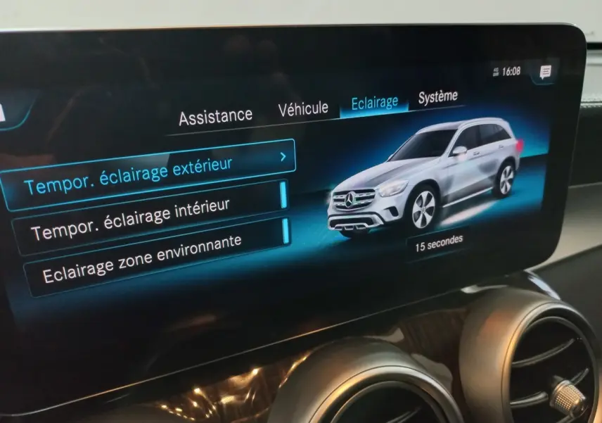 Écran tactile intérieur affichant les réglages d’éclairage avec illustration d’un Mercedes GLC gris en 3/4 avant droit.