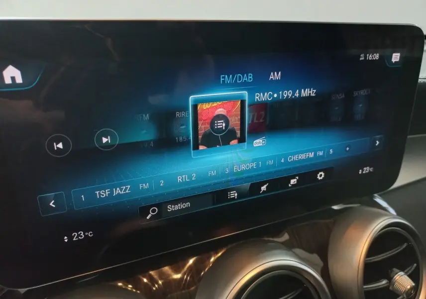 Écran tactile central du Mercedes GLC 300 E Business Line 2021 affichant les stations radio, avec aérateurs ronds chromés en dessous.