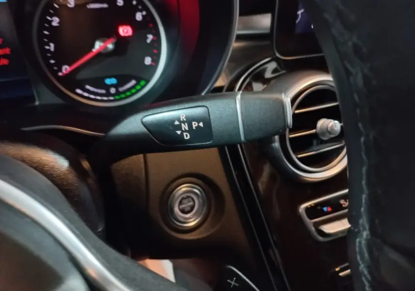 Gros plan sur la commande de boîte automatique et le tableau de bord noir du Mercedes GLC 300 E Business Line 2021 hybride.