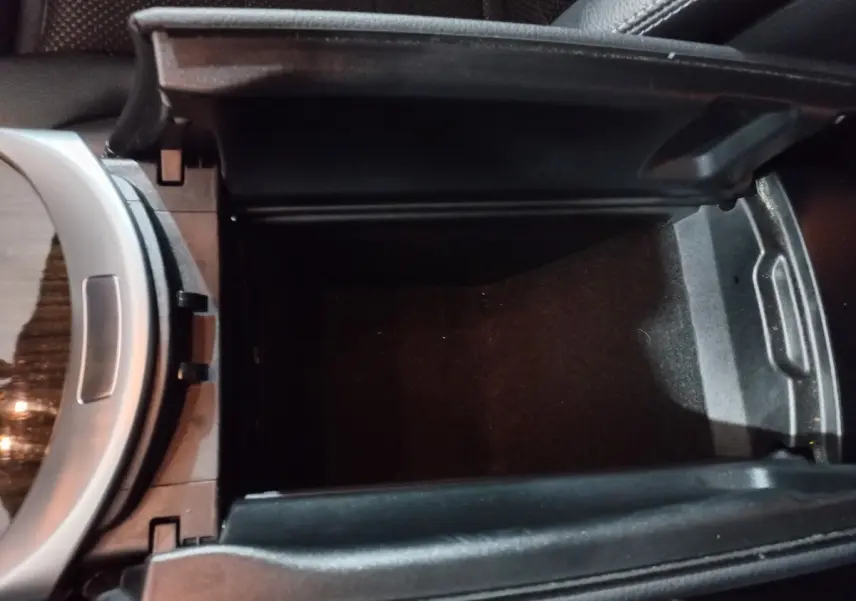 Vue rapprochée de la console centrale noire ouverte du Mercedes GLC 300 E Business Line 2021, intérieur cuir.