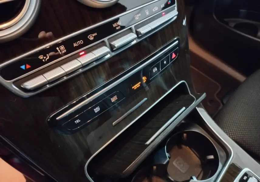 Gros plan sur la console centrale en bois foncé du Mercedes GLC 300 E Business Line 2021, avec commandes climatisation et rangements.