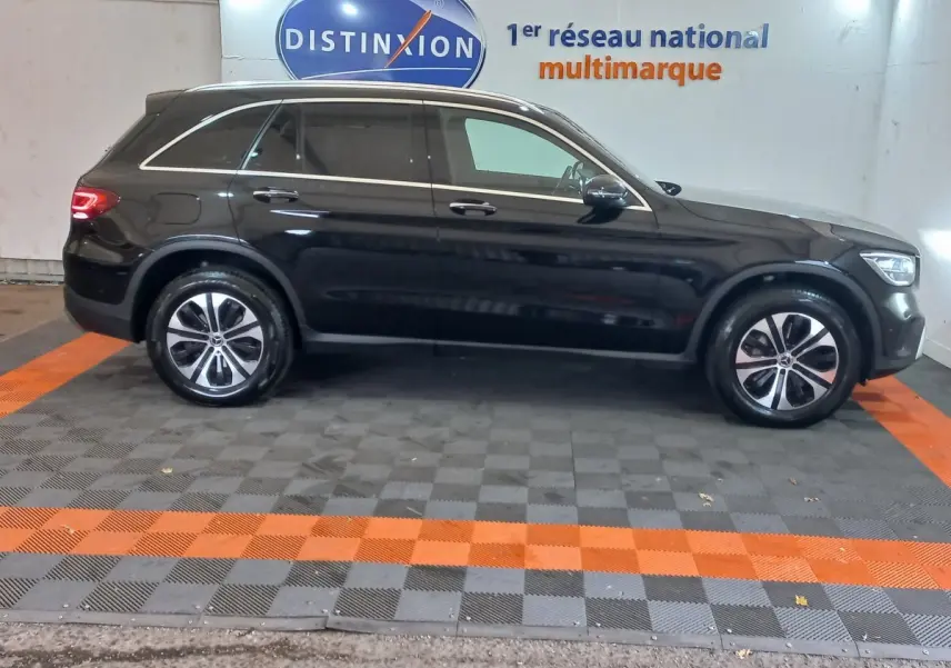 Profil droit d'un Mercedes GLC 300 E Business Line hybride rechargeable noir, roues alliage et vitres teintées.