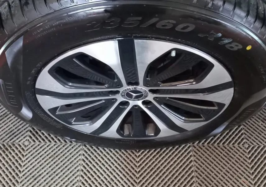 Gros plan sur la jante alliage bicolore et pneu 235/60 R18 du Mercedes GLC 300 E Business Line noir hybride rechargeable.