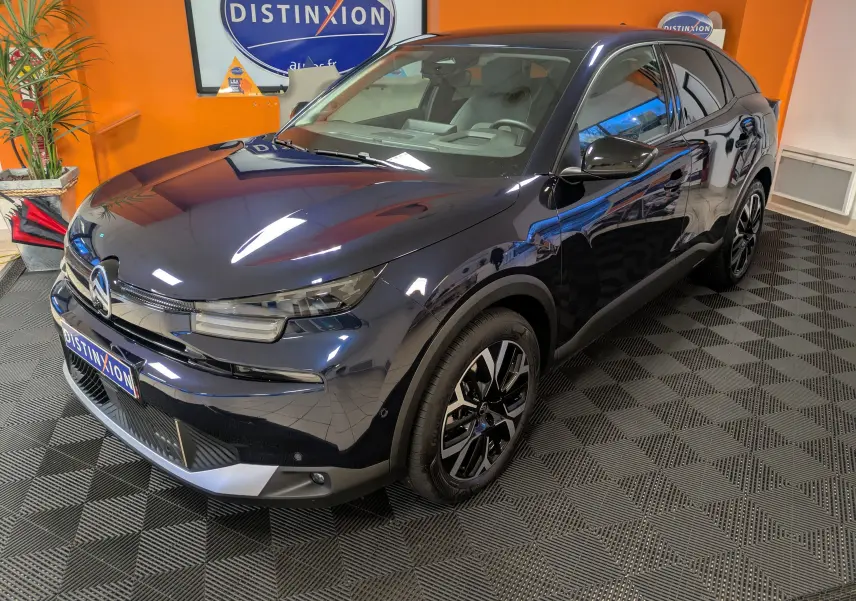 Citroën C4 hybride bleu nuit vue 3/4 avant droit, jantes alliage 18 pouces et intérieur clair visible.