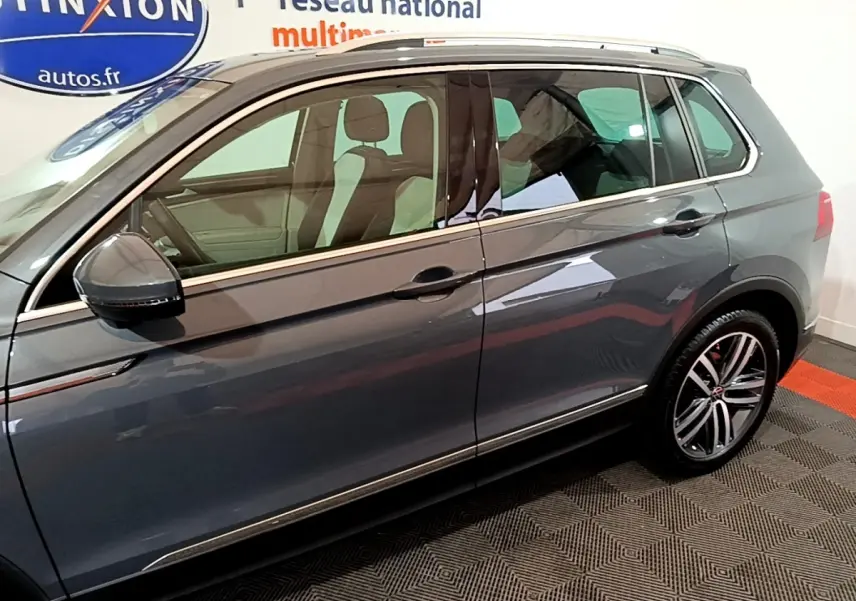 Vue latérale droite d'un Volkswagen Tiguan gris clair 2022 avec jantes alliage et rétroviseurs noirs.