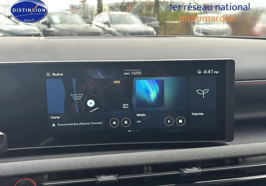 Écran tactile du tableau de bord du Hyundai Tucson blanc sérénité, affichant navigation et options hybrides.