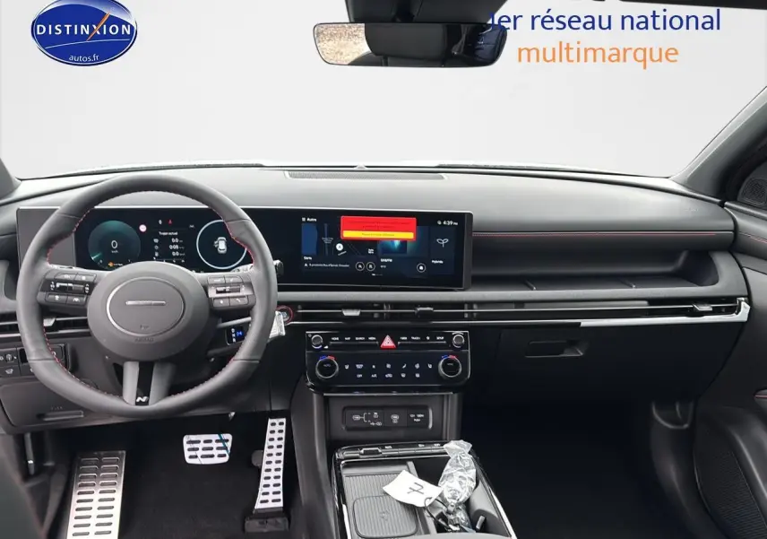 Vue intérieure avant du Hyundai Tucson 2026 blanc sérénité, tableau de bord numérique et volant cuir multifonction N Line.