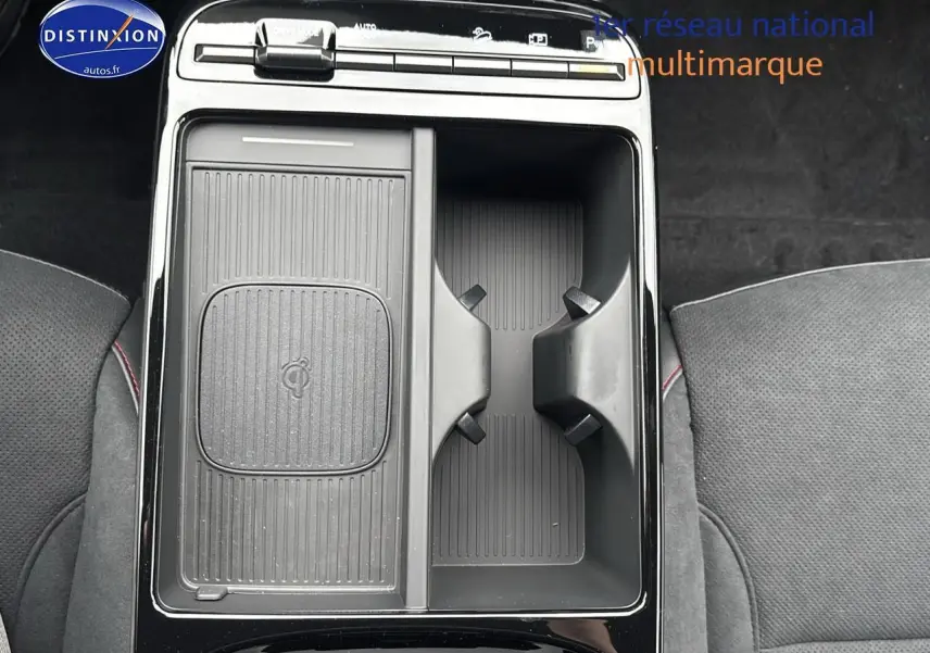 Vue plongeante sur la console centrale noire du Hyundai Tucson 2026 avec compartiments et porte-gobelets visibles.