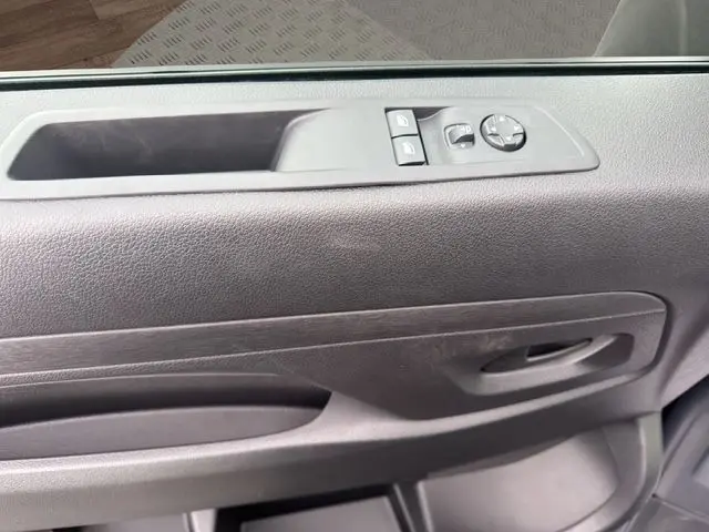 Gros plan sur la porte intérieure côté gauche du Citroën Jumpy noir, avec commandes électriques des vitres et rétroviseurs.