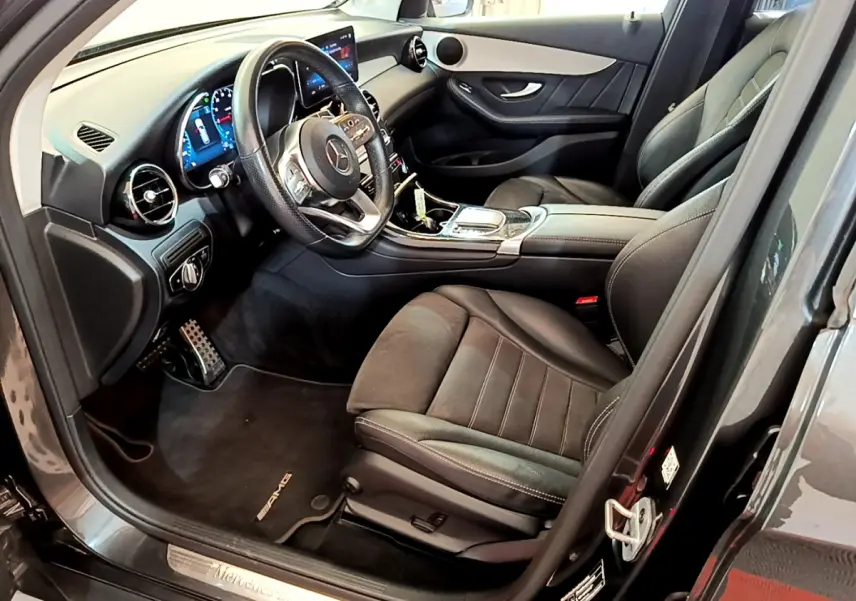 Intérieur côté conducteur du Mercedes GLC 300 E AMG Line 2021, sièges cuir noirs et tableau de bord digital.