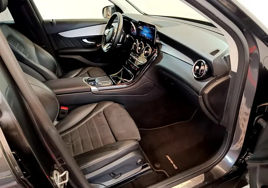 Intérieur avant droit du Mercedes GLC 300 E AMG Line 2021 avec sièges cuir noirs et tableau de bord moderne.