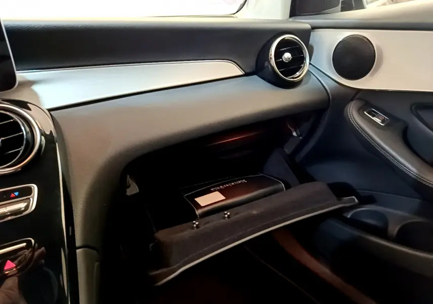 Intérieur Mercedes GLC 300 E AMG Line 2021, vue côté passager sur boîte à gants ouverte et tableau de bord noir et argenté.
