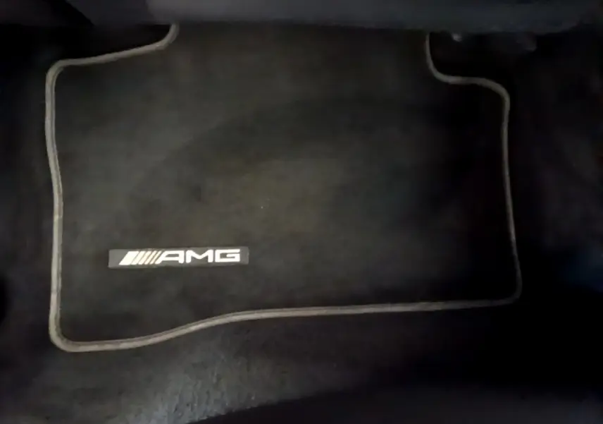 Tapis de sol noir avec logo AMG visible, intérieur du Mercedes GLC 300 E AMG Line hybride rechargeable 2021.