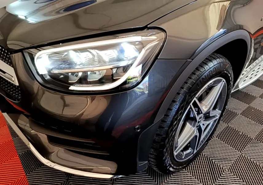 Gros plan sur l'avant droit gris foncé du Mercedes GLC 300 E AMG Line avec phare LED et jante étoile AMG.